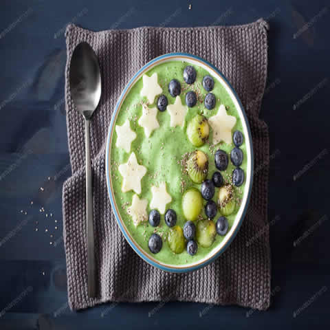 healthy green spinach smoothie bowl with blueberry, apple stars