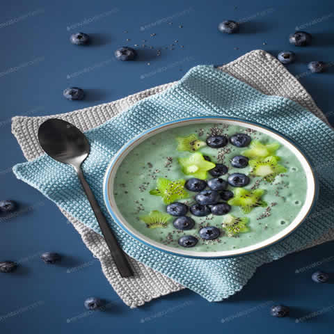 healthy spirulina smoothie bowl with blueberry, kiwi stars, chia